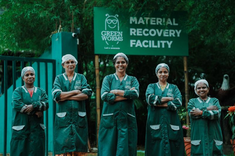 Professional Green Worms Material Recovery Facility team - 5 women workers in green uniforms standing proudly at their facility