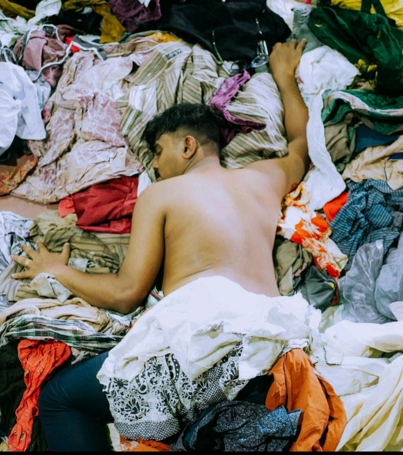 Worker sorting through piles of textile waste in recovery facility